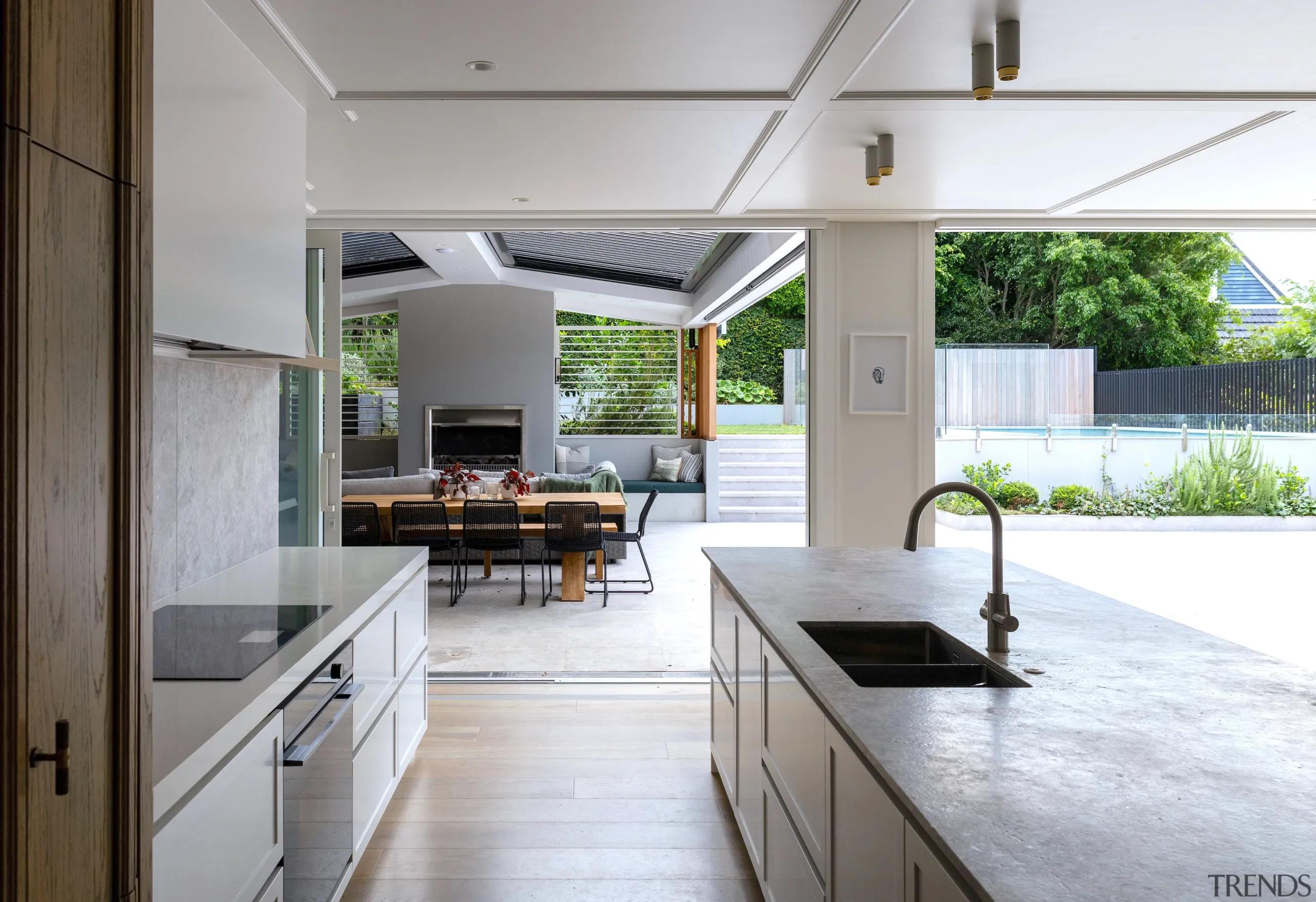 Kitchen and outdoor entertainment area of a renovated tudor home