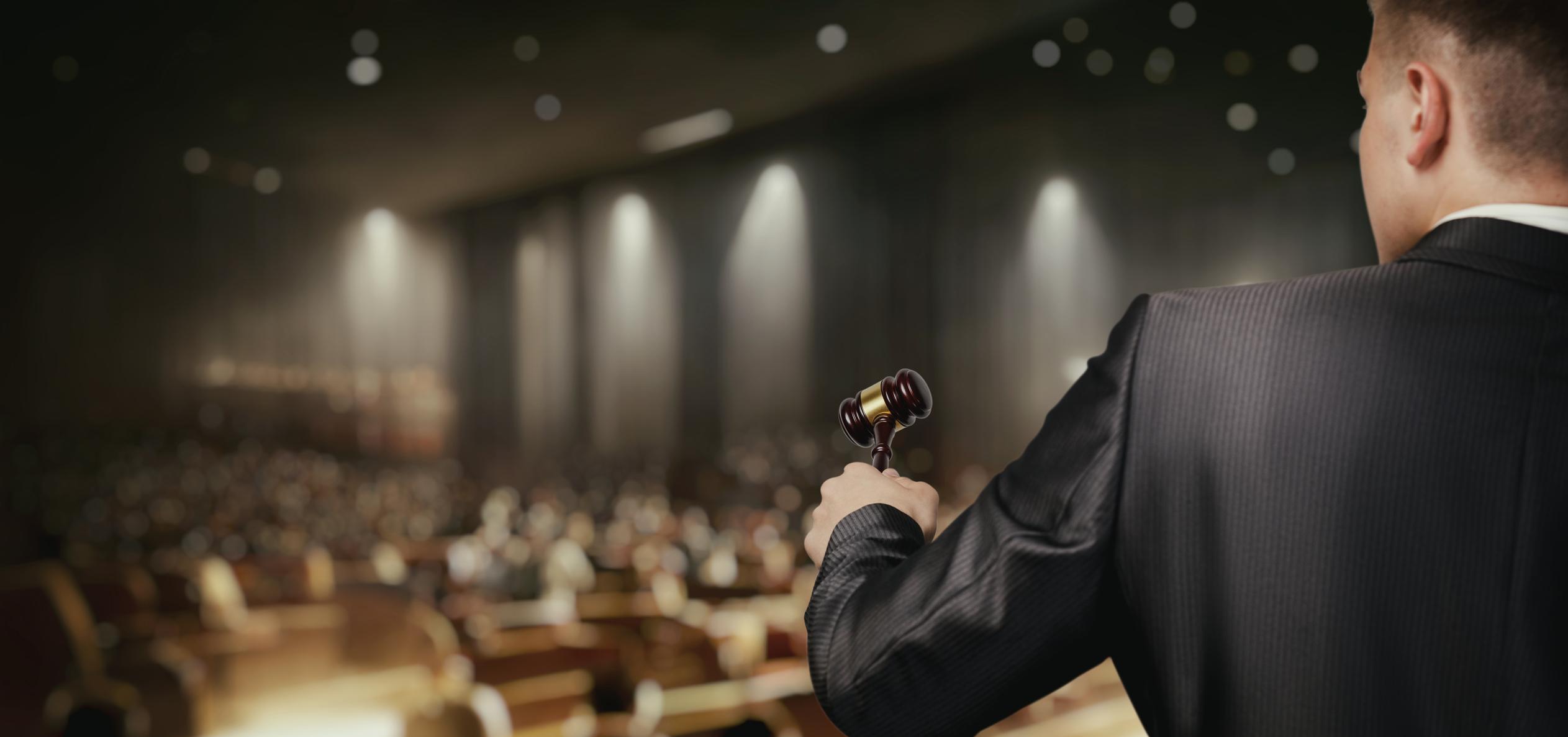 auctioneer at the front of an auction room 