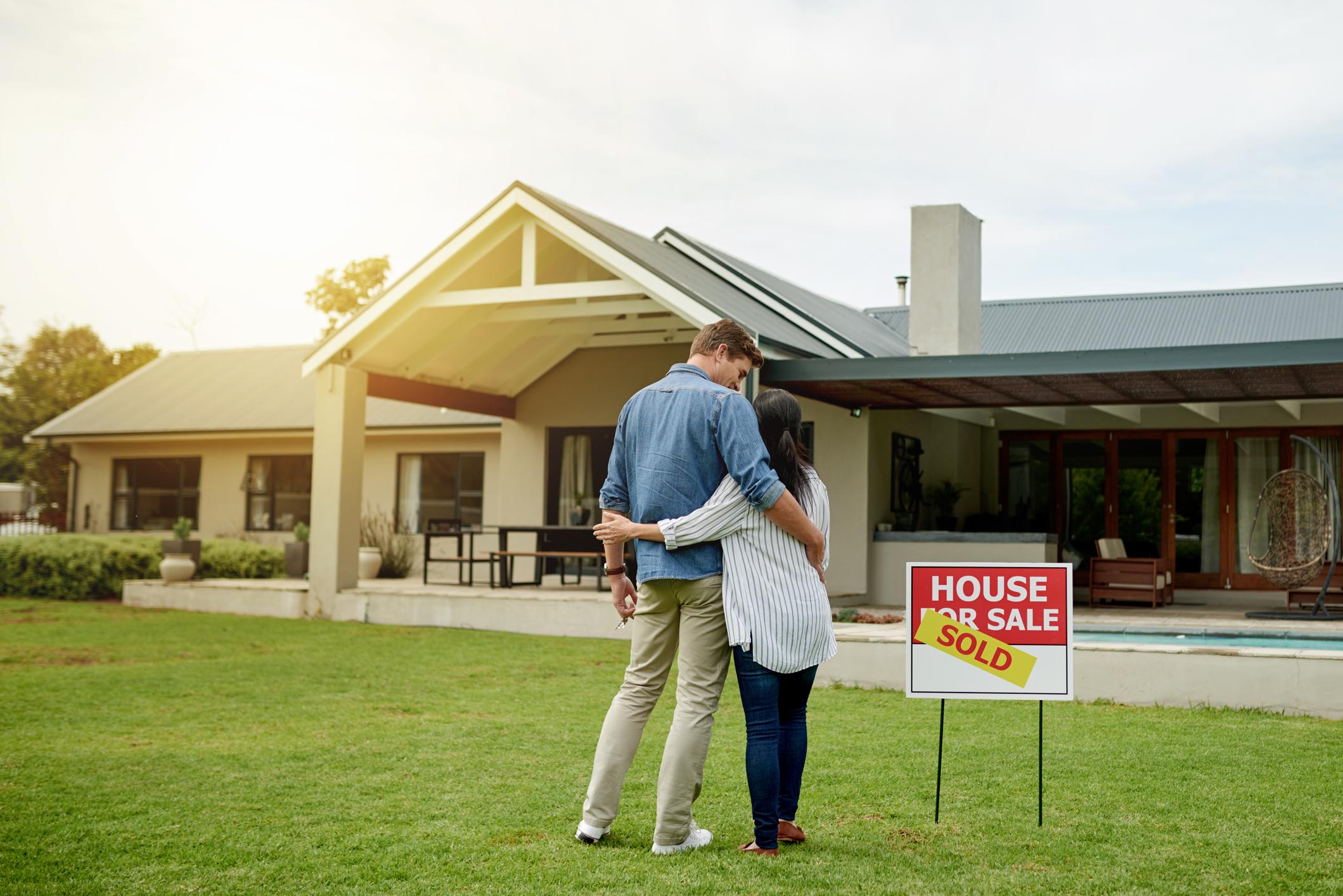 couple outside a sold house